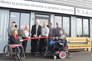 Mayor Ron Vandewal cuts the ribbon, flanked by Dawn and Scott Forbes